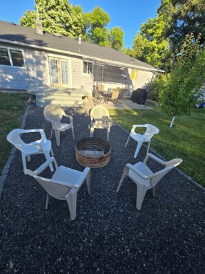 A patio area with outdoor furniture and a fire pit.
