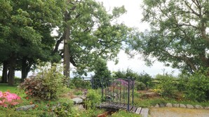 A garden with a metal fence, various plants, and a gravel path. - Cil Y Coed (Gaerwen)