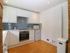 A kitchen with white cabinets, a microwave, an oven, and a refrigerator.