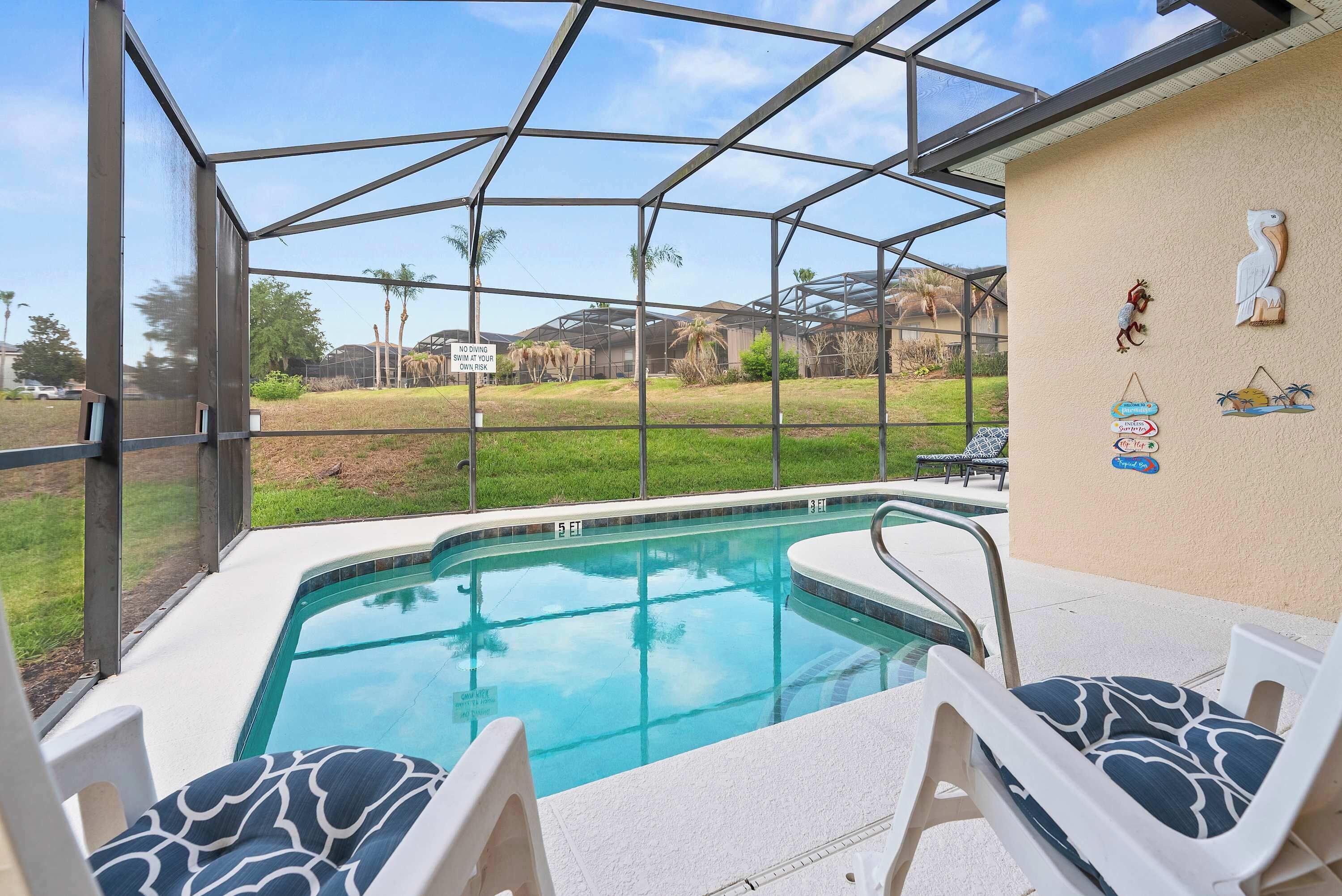 A pool area with clear glass walls, a hot tub, and lounge chairs.