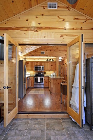 Ein Holzblockhaus-Interieur mit Küche, Essbereich und Bad.