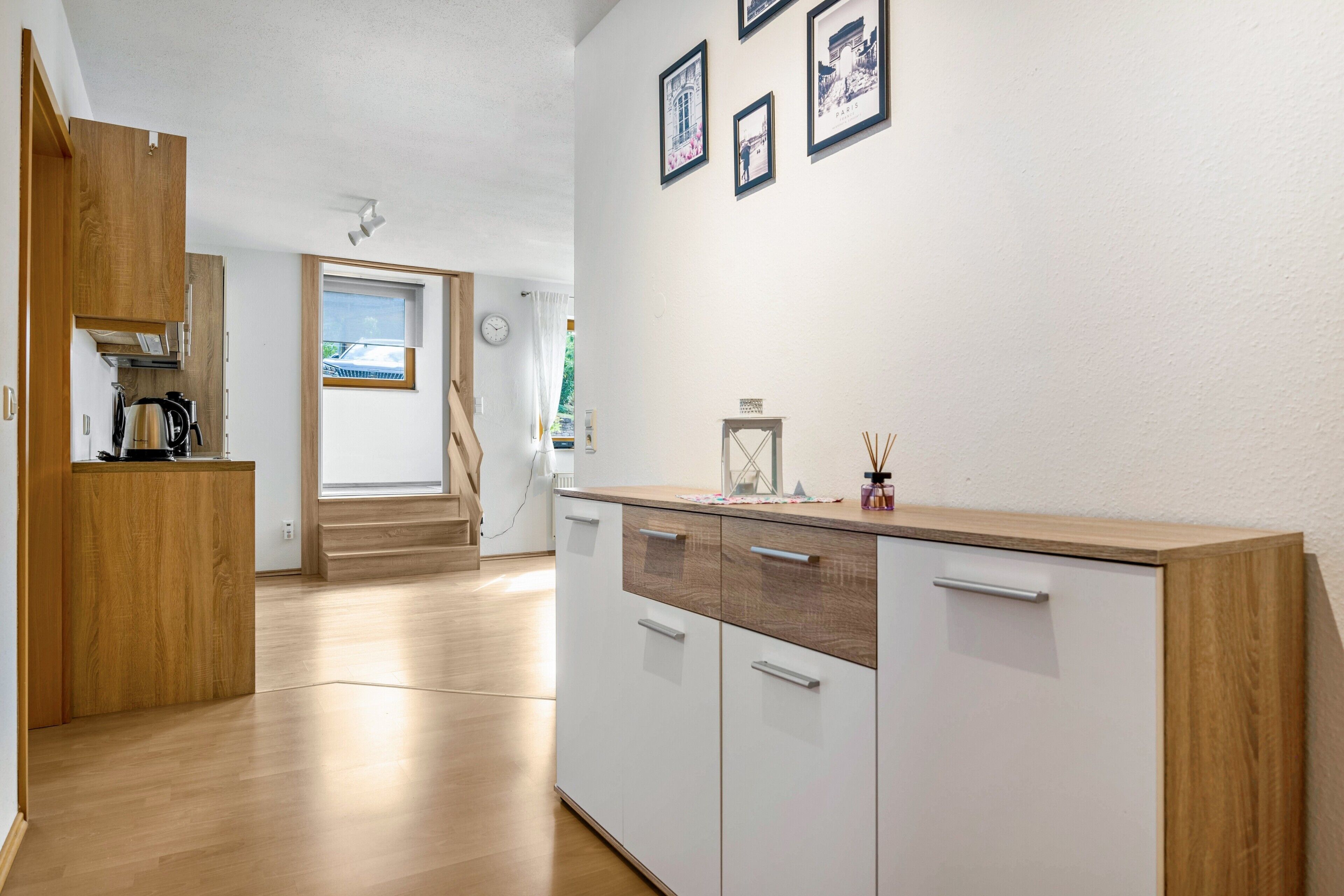 Een moderne keuken met houten kastjes, een aanrecht en een raam.