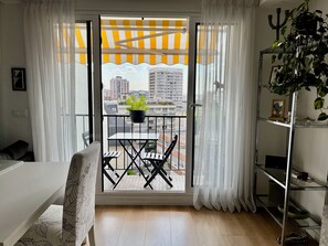 A balcony with a potted plant, a table, and chairs. - A beautiful, modern Parisian apartment, bathed in light, spacious, and airy. (Charenton-le-Pont)