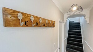 En väggmonterad skylt i trä med bokstäver formade som skedar, som tillsammans bildar ordet ”COATELLO”.