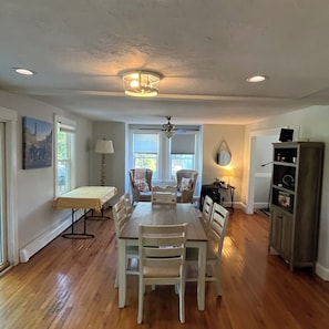 A dining area with a table and chairs, a ceiling fan, and a cabinet. - 20 Minutes to Gillette Stadium: Perfect World Cup 4-Bedroom House (Westwood)