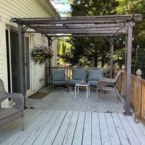 A covered porch with wicker furniture, a patterned rug, and hanging flower baskets. - 20 Minutes to Gillette Stadium: Perfect World Cup 4-Bedroom House (Westwood)