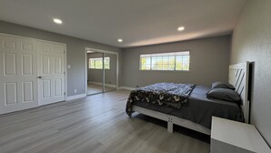 Una camera da letto con un letto, una finestra e un ingresso che conduce a un'altra stanza.