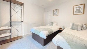 Ein Schlafzimmer mit zwei Betten, einem Kleiderschrank und einer Heizung.