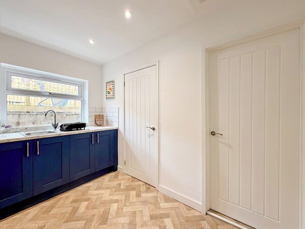 A kitchen with a window, a sink, and cabinets.
