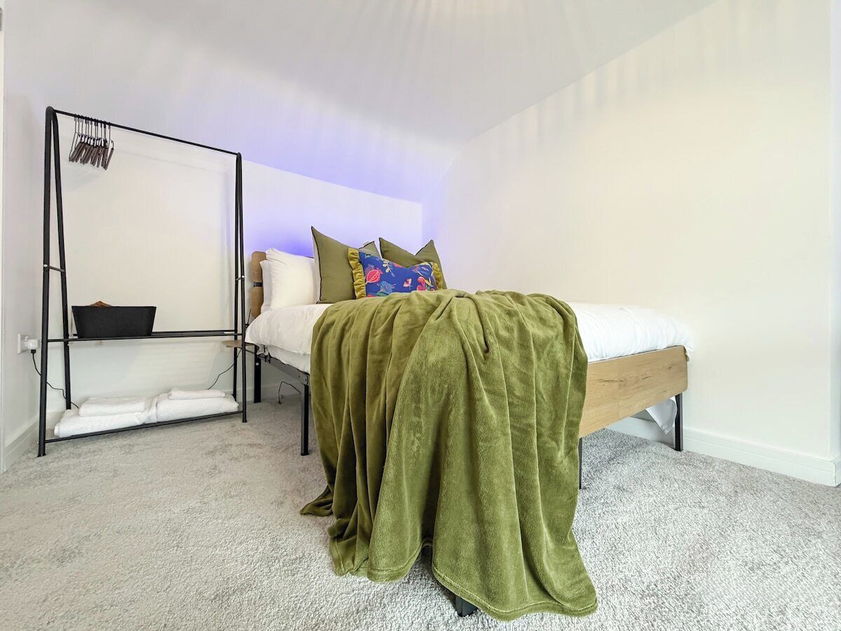 Une chambre avec un lit, un portant et une couverture.