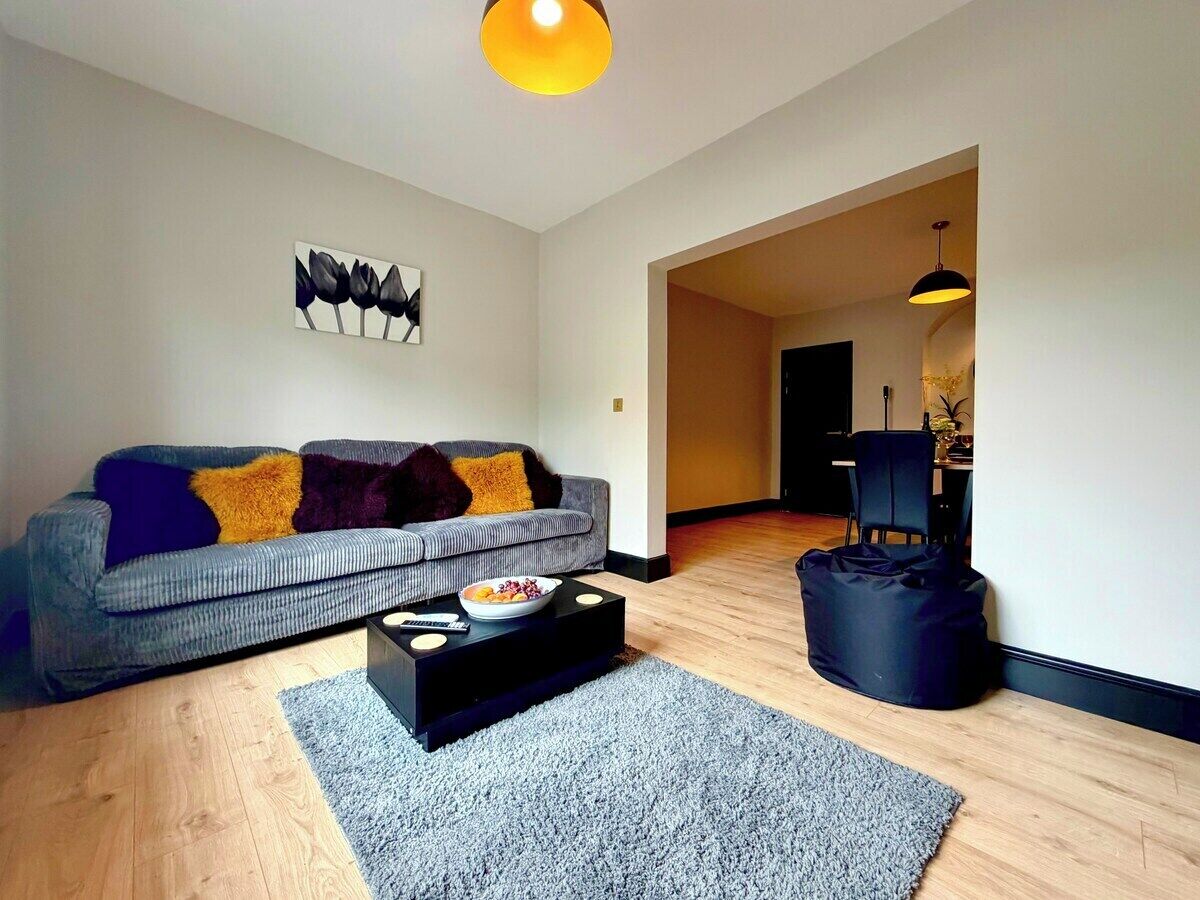 A living room with a sofa, coffee table, and a black bag.