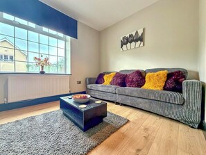 Una sala de estar moderna con un sofá, una mesa de centro y una ventana con vistas.