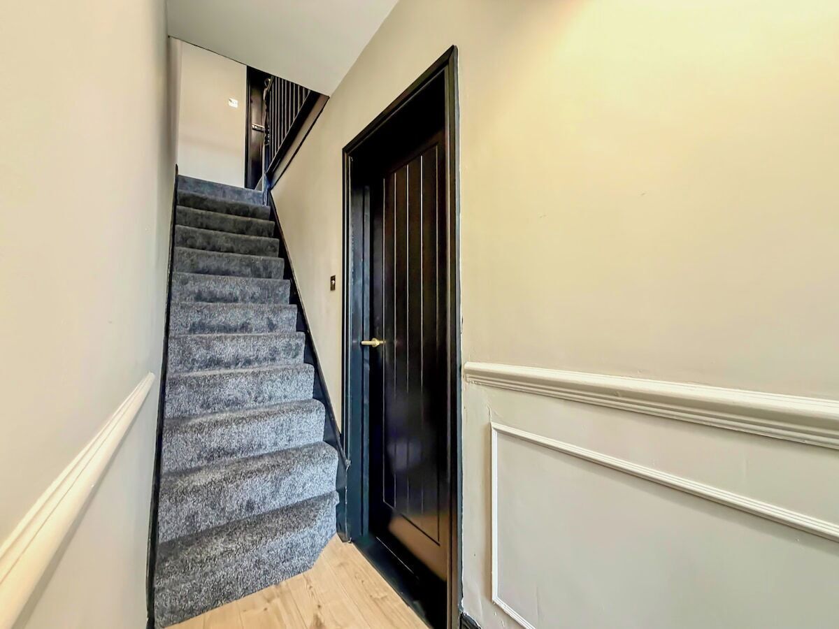 A staircase with a dark door and white trim.