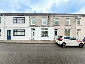 A row of terraced houses with a white car parked in front.
