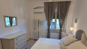 Een slaapkamer met een bed, een kaptafel en een plafondlamp.
