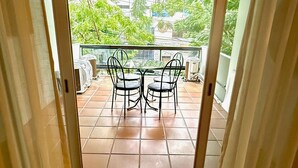 A view through a doorway to an outdoor patio with a table and chairs, a tiled floor, and a railing. - Raridade Ape 4 Quartosmeirelesbeira Mar180m2 (Fortaleza)
