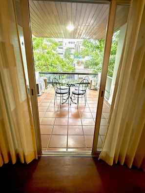 A view through a doorway to an outdoor patio with a table and chairs, a tiled floor, and a railing. - Raridade Ape 4 Quartosmeirelesbeira Mar180m2 (Fortaleza)
