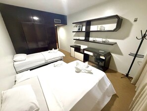 A hotel room with two beds, a desk, a chair, a mirror, and a coat rack. - Raridade Ape 4 Quartosmeirelesbeira Mar180m2 (Fortaleza)
