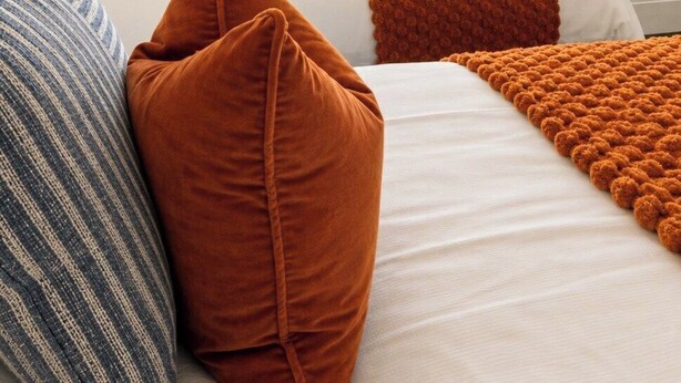 A hotel room with a bed, pillows, a blanket, and a window with blinds. - Coastal Getaway 5-bed Sleeps 10 | DN35 (North East Lincolnshire)