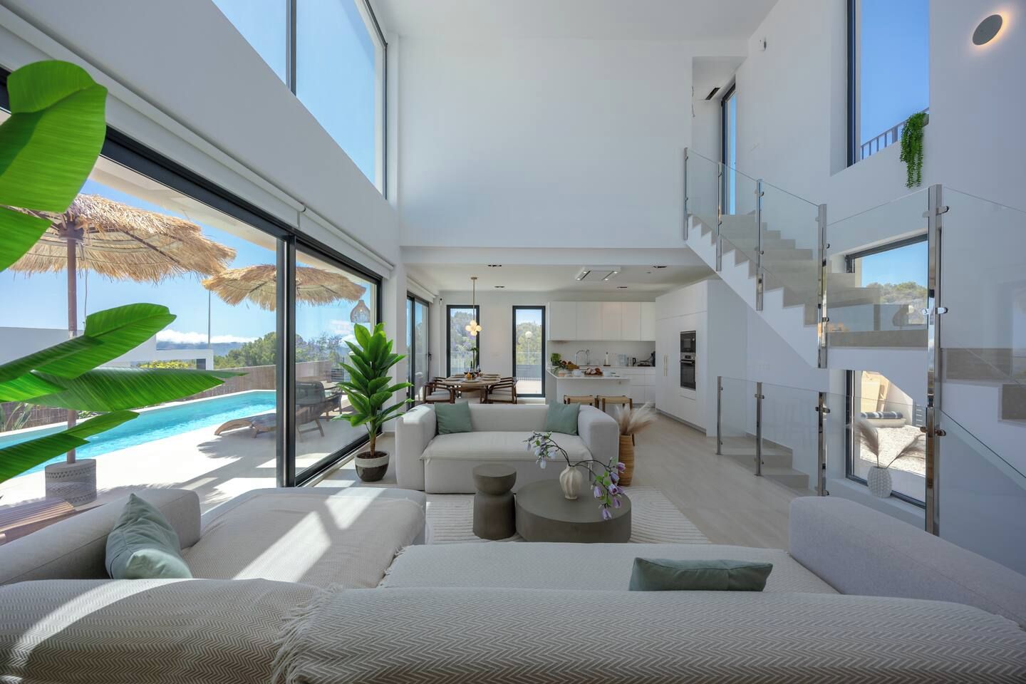 A modern interior with a pool, a staircase, and a dining area.