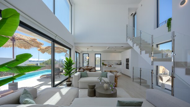 Un interior moderno con un gran ventanal, una piscina y una escalera.