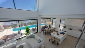 Un espacio habitable moderno tipo loft con piscina, comedor y cocina.