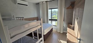 A room with a bunk bed, a window with curtains, and a wardrobe. - Casa Duplex no Condominio Bella Arte (Aquiraz)