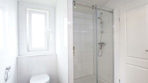 A modern bathroom with a glass-enclosed shower, a toilet, and a window. - Holiday Home in Belfeld With Terrace (Belfeld)