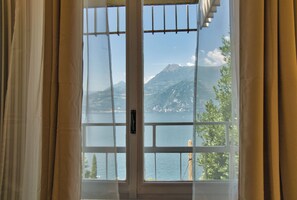 Une fenêtre donnant sur une montagne et un plan d’eau.