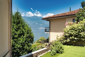 Une maison dotée d’un balcon donnant sur un lac et des montagnes.