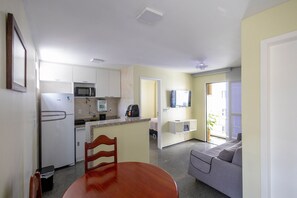 Ein gemütlicher Wohnbereich mit Küchenzeile, Essplatz, Sofa und Fernseher.