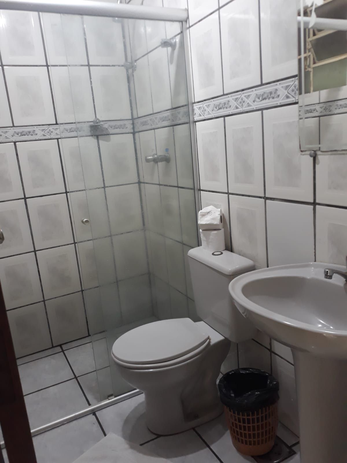 Un baño con inodoro, lavamanos y zona de ducha.