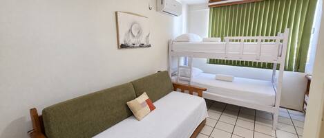 Un lit superposé avec un matelas blanc et un rideau vert.
