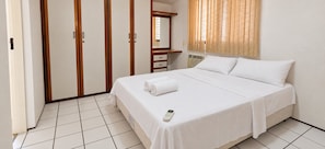 A hotel room with a bed, a bedside table, a mirror, a window with blinds, and a thermostat. - Ape Familia 200 Metros da Feirinha Beira mar 502 (Fortaleza)