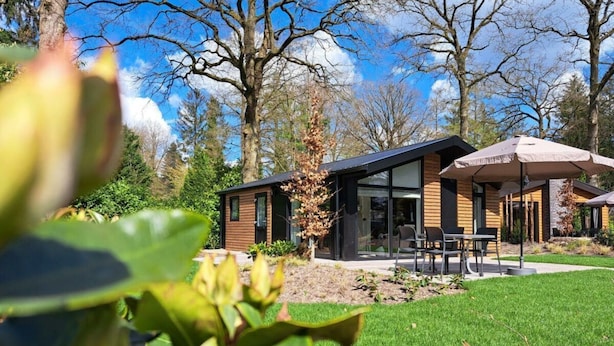 A modern building with a glass facade, outdoor seating, and a well-maintained lawn. - Holiday Home in Maarn With Wi-fi (Maarn)
