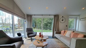 A modern living room with a sofa, armchair, and coffee table. - Holiday Home in Maarn With Wi-fi (Maarn)