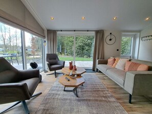 Een moderne woonkamer met een bank, fauteuil en salontafel.