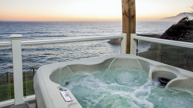 Ein Whirlpool mit Blick auf den Ozean bei Sonnenuntergang.