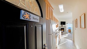 Eine moderne Küche mit Steinrückwand, Holzschränken und einem eingebauten Backofen.