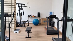 A gym with exercise equipment, a blue exercise ball, and a water dispenser. - Ape Familia 3 Quartos 200m da Feirinha Beira mar (Fortaleza)
