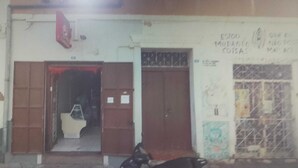 A building entrance with a set of double doors, a small step leading inside, and a motorcycle parked outside.