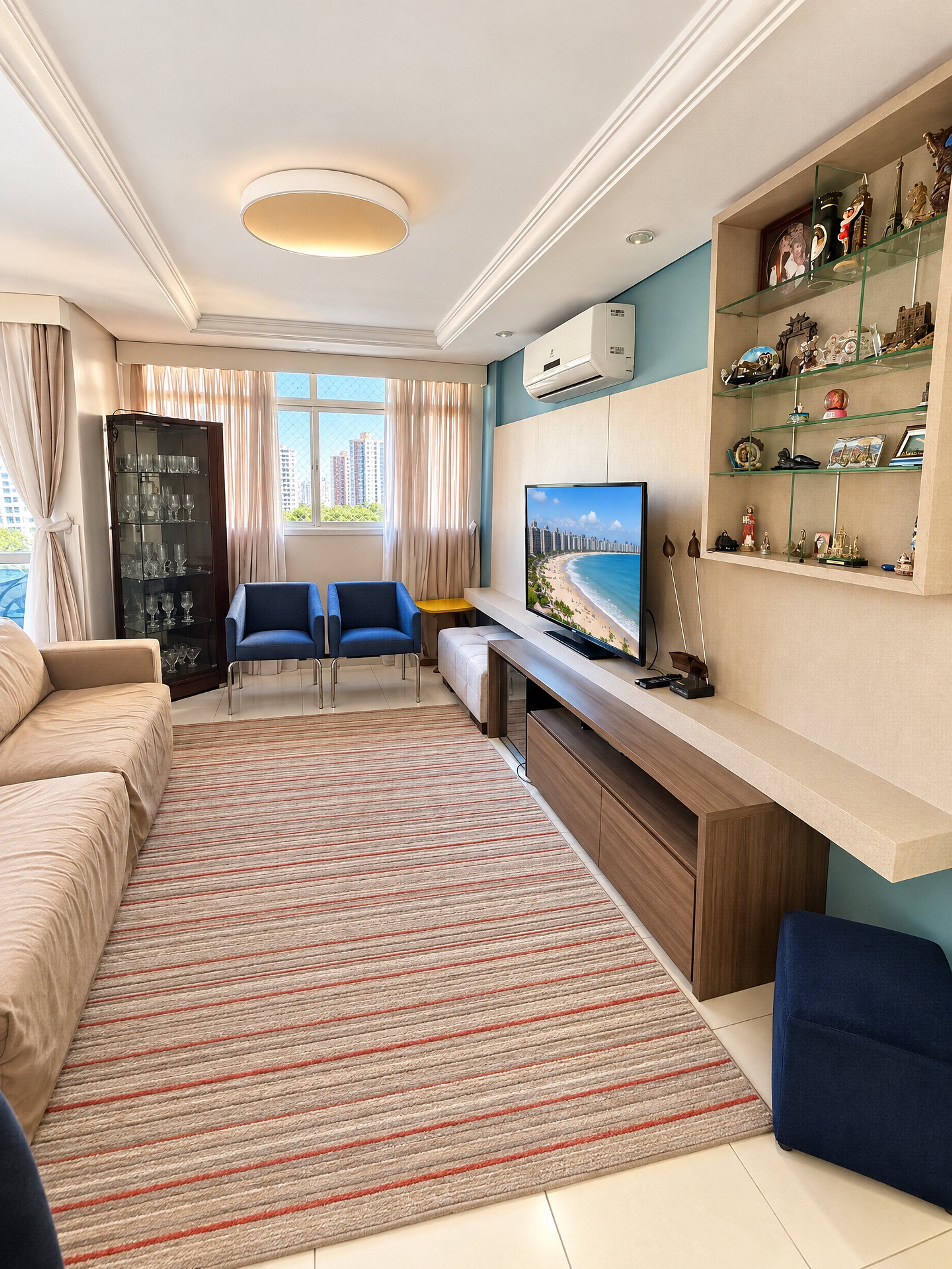 A modern living room with a sofa, a TV, a coffee table, and a bookshelf.
