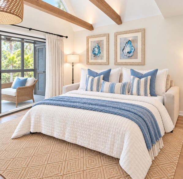 A bedroom with a large bed, a view of palm trees, and artwork on the wall.