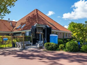 A building with a red-tiled roof, a signboard with EuroParc logo, and a paved entrance area with benches. - Holiday Home in Velsen-zuid With Terrace (Velsen-Zuid)