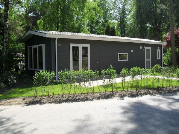 A single-story building with a dark exterior, white-framed windows, and a small porch area. - Holiday Home in Velsen-zuid With Terrace (Velsen-Zuid)