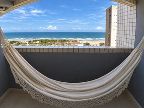 A hammock in a balcony with a view of the beach and ocean. - Beautiful Apartment With sea View 2 Bedrooms (Fortaleza)