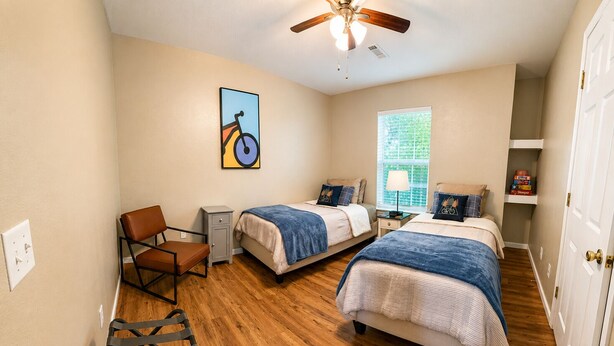 A bedroom with two beds, a desk, a chair, a ceiling fan, and a window. - Ozark Calling -- Ride-In Ride-Out MTB Basecamp, Premium Location (Bella Vista)