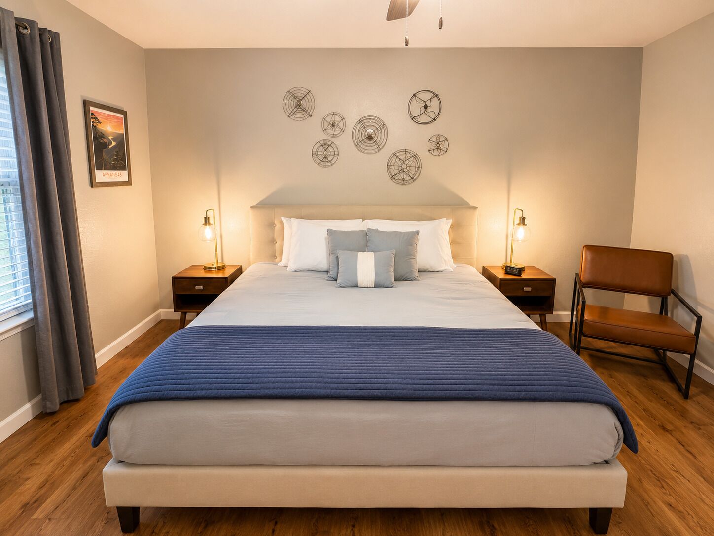 Una camera da letto con un letto grande, due comodini con lampade, una sedia e una parete con decorazioni circolari.