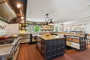A kitchen with a central island, a stove, and a sink.