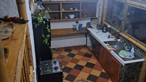 A kitchen with a checkered floor, a stove, a sink, and a window.